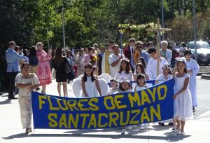 Procession of people holding the sign "Flores De Mayo Santacruzen"
